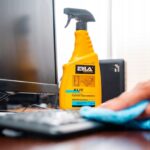 Spray do czyszczenia plastików i mebli ogrodowych Erla Kliv obok monitora, osoba przeciera klawiaturę.