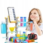 Dziewczynka eksperymentuje z zestawem chemicznym i zastanawia się nad wynikami. Kolorowe probówki w tle.
