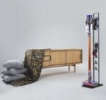 Bezprzewodowy odkurzacz w nowoczesnym wnętrzu z szafką, tkaniną i poduszkami. Idealny do stylowych domów.