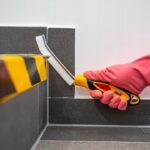 Czyszczenie trudno dostępnych miejsc szczotką ręczną w rękawicy, dokładne sprzątanie narożników płytek.