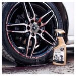 Butelka środka czyszczącego K2 Roton obok felgi samochodowej, widoczne efekty czyszczenia.