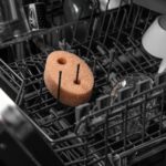 Gąbka do naczyń w zmywarce otoczonej naczyniami, skuteczne czyszczenie kuchennego sprzętu.