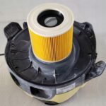 Filtr powietrza do odkurzacza przemysłowego, z żółtymi plisami, w czarnej obudowie na jasnym tle.