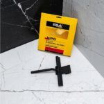 Czarna silikonowa ściągaczka VIPO do wody ERLA na tle marmurowej podłogi i czarnej ściany z opakowaniem w tle.