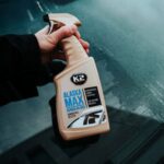 Odmrażacz do szyb K2 Alaska Max w dłoni, przygotowany do usuwania lodu z szyby samochodowej.