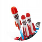 Trzy czerwono-białe zabawkowe rakiety na wyrzutni, gotowe do startu. Idealne do kreatywnej zabawy dla dzieci.