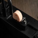 Gąbka i dozownik na mydło w nowoczesnej czarnej kuchni. Elemente stylowego wnętrza.