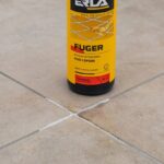 Butelka płynu Fuger do czyszczenia fug na tle płytek ceramicznych. Efektywne usuwanie zabrudzeń z fug.